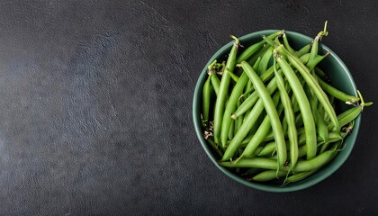 Wall Mural - Green bean in a bowl on a black background, top view, copy space