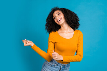 Sticker - Photo portrait of attractive young woman dancing look empty space dressed stylish yellow clothes isolated on blue color background