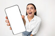 © New Africa - Happy woman showing mobile phone with blank screen on white background. Mockup for design