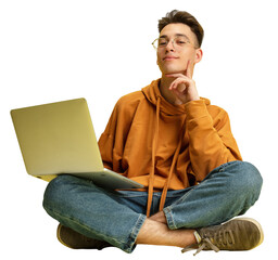 Studying, doing homework. One young smiling Caucasian man, student in glasses sits on floor with laptop against transparent background. Education, studying and student life concept.