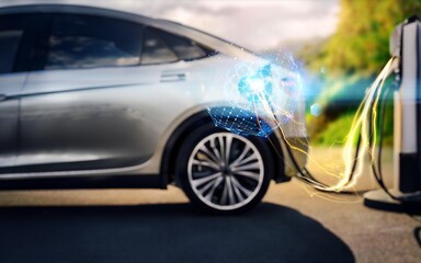 A silver electric vehicle is charging with a cable plugged into the charging station. The image is blurred and has a graphic of blue and yellow lightning around the car.