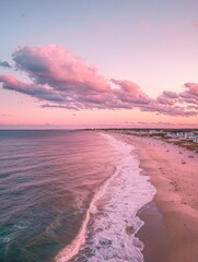 Sticker - The pink sky of the evening is painted by clouds, and in front, you can see an endless beach with buildings along it