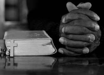 black man praying to god with crucifix and hands together Caribbean man praying on black background with people stock photos stock image	