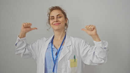 Wall Mural - Confident woman doctor pointing at herself with thumbs against a white background, showcasing professionalism and positivity.