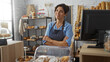 © Krakenimages.com - Hispanic woman in bakery with arms crossed and various pastries displayed indoors