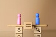 © New Africa - Gender equality concept. Cube with equals sign between male and female figures on scales against beige background