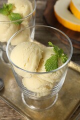 Wall Mural - Scoops of melon sorbet and mint in glass dessert bowls on table, closeup