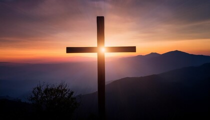 silhouette of a wooden cross stands prominently against a breathtaking sunset backdrop on a mountain. The dramatic interplay of light and shadow highlights the cross, creating a serene and sacred atmo