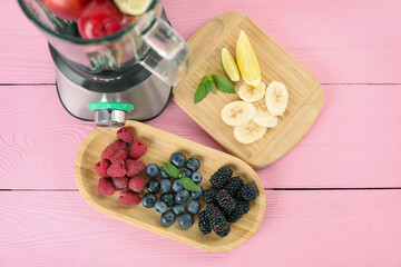 Canvas Print - Blender and fresh ingredients on pink wooden table, top view