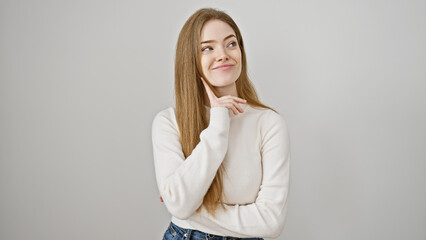 Wall Mural - A thoughtful young caucasian woman with blonde hair wearing a sweater isolated against a white background, exuding beauty and youth.