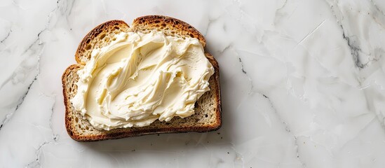 Sticker - Top down view of a slice of bread spread with delicious cream cheese on a white marble surface with room for text in the image s background. Creative banner. Copyspace image