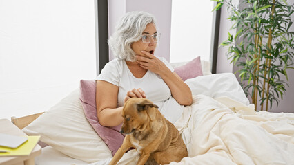 Sticker - A surprised elderly woman with grey hair in bed with her dog in a cozy bedroom setting with plants