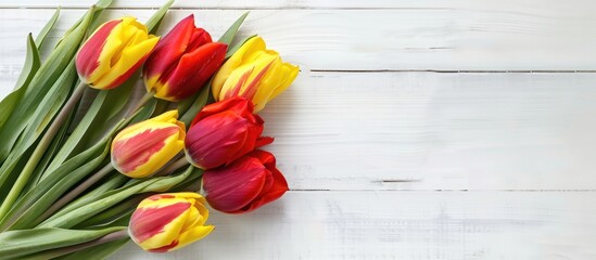 Fototapete - Red and yellow tulip bouquet on a white table top view suitable for mock up designs with copy space image