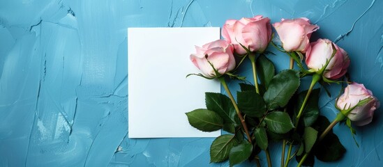 Poster - Pink roses and a white blank on a blue backdrop creating a serene copy space image