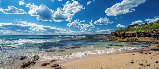 Wall Mural - scenic coastal view with clear blue skies and fluffy clouds on a sunny day featuring a wide copy spa