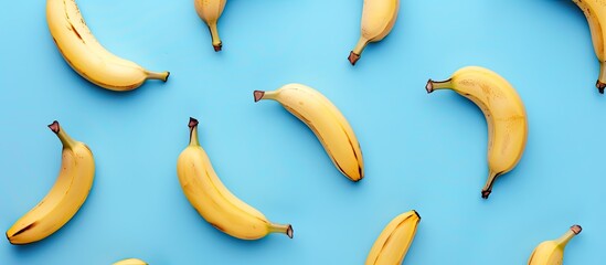 Wall Mural - Top view of a healthy and simple raw food concept with a banana pattern on a blue background in a flat lay style shot with copy space image