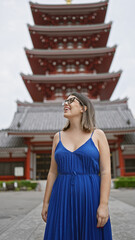 Sticker - Cheerful, beautiful hispanic woman with glasses joyfully exploring and admiring the majestic senso-ji temple as she casually strolls, looking around with awe and a confident smile.