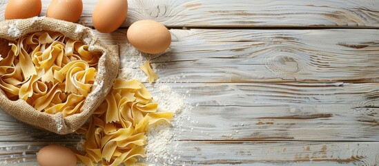 Wall Mural - White wooden table with a bag of pasta made with eggs and flour providing copy space image