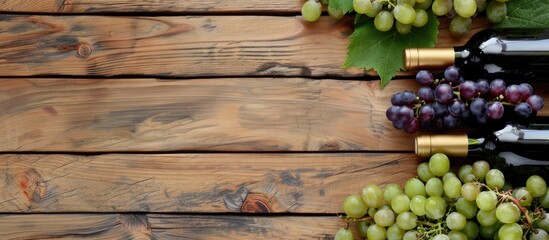 Leinwandbilder - Top view of wine bottles and a bunch of grapes on a wooden surface featuring a copy space image
