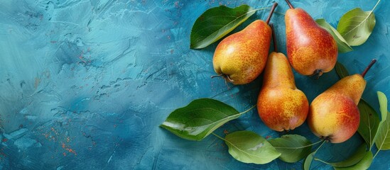 Poster - Fresh pears and leaves on a blue backdrop with copy space image