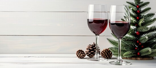 Poster - Holiday concept depicted with a Christmas tree cones and two wine glasses set on a white wooden backdrop offering a charming copy space image