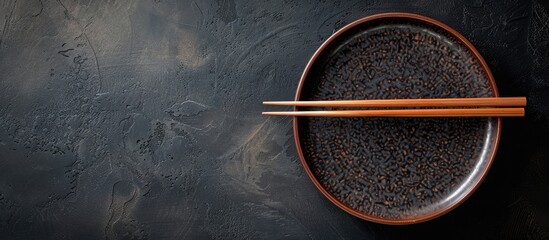 Leinwandbilder - A traditional Japanese chopstick plate is seen from above on a dark backdrop providing copy space for additional content