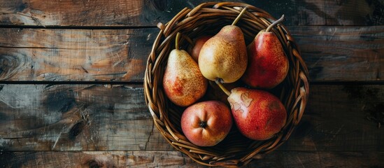 Wall Mural - copy space image of organic ripe pears displayed in a rustic basket on a wooden table promoting heal