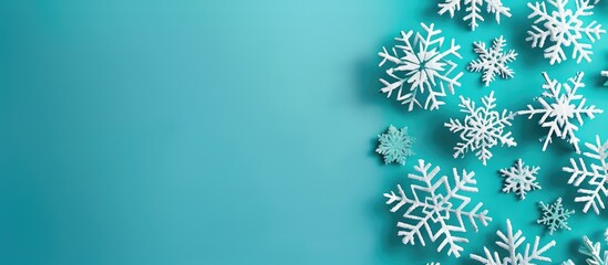 Poster - Festive snowflakes decorations set against a vibrant turquoise backdrop with copy space image