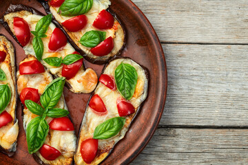 Poster - Italian mini pizza . Aubergine (eggplant ) with mozzarella cheese and basil . On rustic background