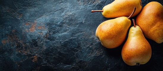 Poster - Organic food concept featuring ripe summer pears against a dark stone background with copyspace