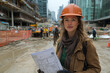 © 3M16 - portrait of a woman with a helmet and blueprints in her hands at a construction site