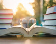 © Iqy - An open book with pages folded into a heart shape, surrounded by more books. National Read a Book Day Concept