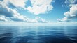 © Aris Suwanmalee - A vast, tranquil ocean stretches out beneath a clear blue sky dotted with fluffy white clouds.  The sun glints off the water, creating a peaceful and serene atmosphere.