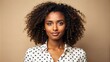 © Sirinporn - Smiling woman with dark skin and curly hair wears a bright white polka-dot blouse, exuding confidence and warmth against a neutral background.