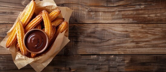 Churros with warm chocolate sauce displayed on a rustic wooden table with ample copy space image