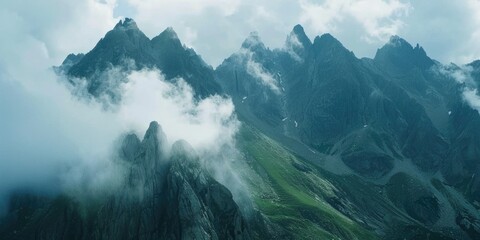 Wall Mural - Majestic mountain peaks under a blanket of clouds.