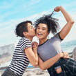 © Frank Coop/peopleimages.com - Friends, kiss and beach portrait on holiday, travel together and happiness on weekend trip. People, women and outdoor for security in relationship by ocean, energy and bonding on promenade by sea