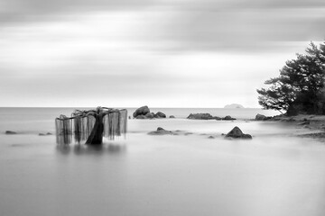 Ongjin-gun, Incheon, South Korea - July two, 2016: black and white, with long exposure of a sculpture of willow shape on the sea at high tide against horizon at Modo Island