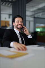 Wall Mural - A man in a suit is talking on his cell phone. He is smiling and he is enjoying the conversation