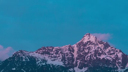 Wall Mural - 4K Time lapse shot of snow covered Himalayan mountain peak during the sunset as seen from Keylong in Lahaul and Spiti district, Himachal Pradesh, India. Snowy Himalayas during the blue hour. 