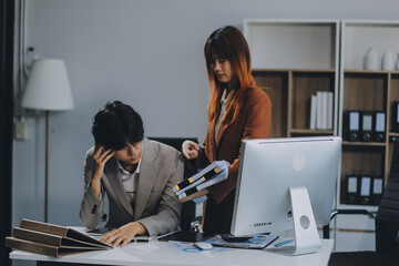 Stressed business couple working at big cabinet. Frustrated director closed face with hands at laptop workplace interior. Woman partner solving problems on smartphone call feeling nervous at office