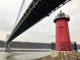 Red Lighthouse Beneath Bridge on a Cloudy Day