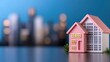 © weerasak - A charming pink model house on a blurred city background, depicting a cozy home concept in an urban setting.