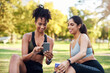 © Chanelle2000/peopleimages.com - App, fitness and phone with woman friends outdoor in park together for workout routine. Exercise, social media and tracking progress with athlete people on lawn for challenge, performance or training
