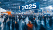 © h3design - Visitors explore an expansive exhibition space bustling with activity, highlighted by a large banner displaying the year 2025