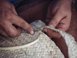 © ADDICTIVE STOCK CORE - Close-up of hands skillfully weaving a palmito basket