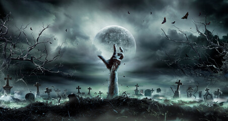 zombie hand rising out of a graveyard - halloween