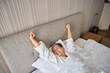 © Viacheslav Yakobchuk - Beautiful woman waking up, stretching hands after good night sleep in hotel