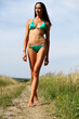© Andrey_Arkusha - Young slim model in a green bikini walking on rural path