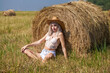 © Andrey_Arkusha - Young beautiful blonde girl in a straw hat posing in the hayloft